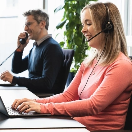 A lady and a man sitting at their desks